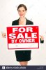 for-sale-by-owner-sign-held-up-by-a-sexy-business-woman-BTRYM2.jpg