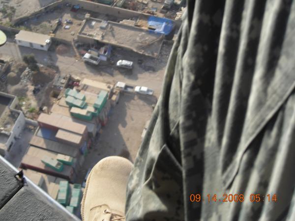 feet out of a blackhawk somehwere over baghdad